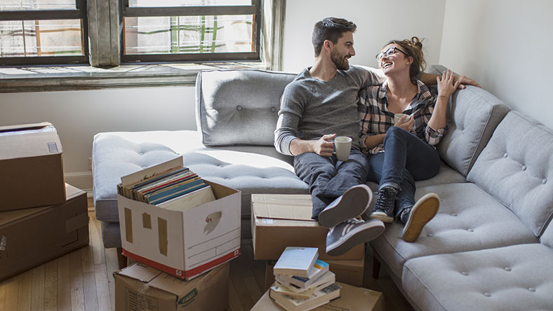 Couple relaxing on couch while moving into new home 