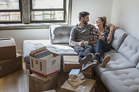 Couple relaxing on couch while moving into new home