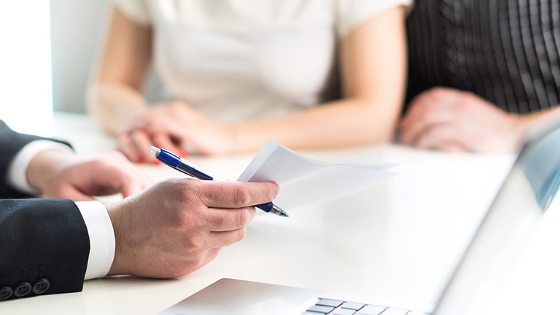 A young defacto couple completing their tax return with a tax agent
