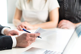 A young defacto couple completing their tax return with a tax agent