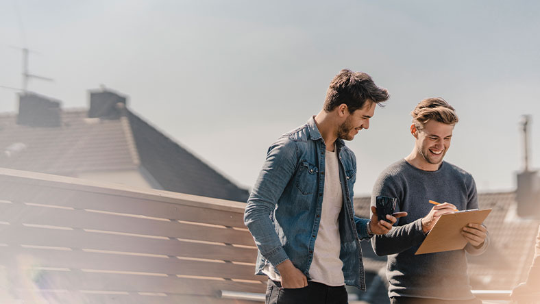 Two men filling in form outside home