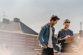 Two men filling in form outside home