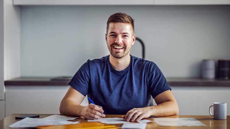 Man sitting at dining table doing paperwork for home loan