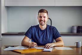 Man sitting at dining table doing paperwork for home loan