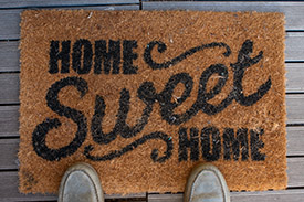 A doormat to a home owner's property reading 'Home sweet home'.