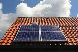 A rooftop with a grid of solar panels on a sunny day.