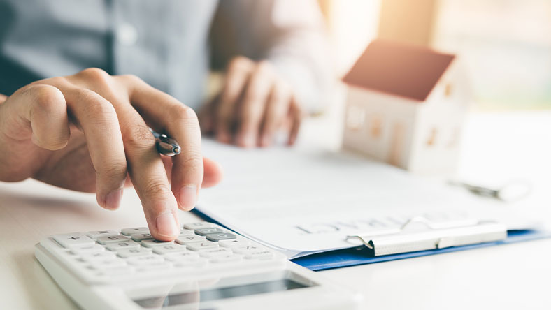 Close up of desk with male hands using clipboard and calculator