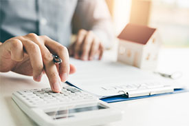 Close up of desk with male hands using clipboard and calculator