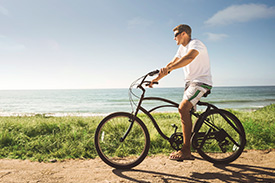 Man rides bike along beautiful coast