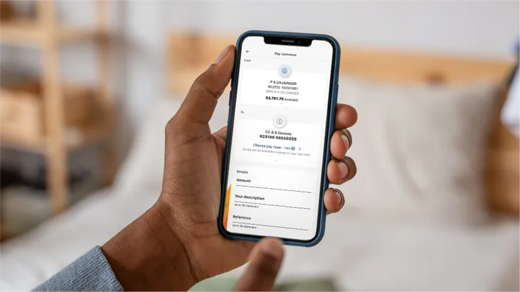A person holds a smartphone in one hand while viewing an online payment or subscription screen.